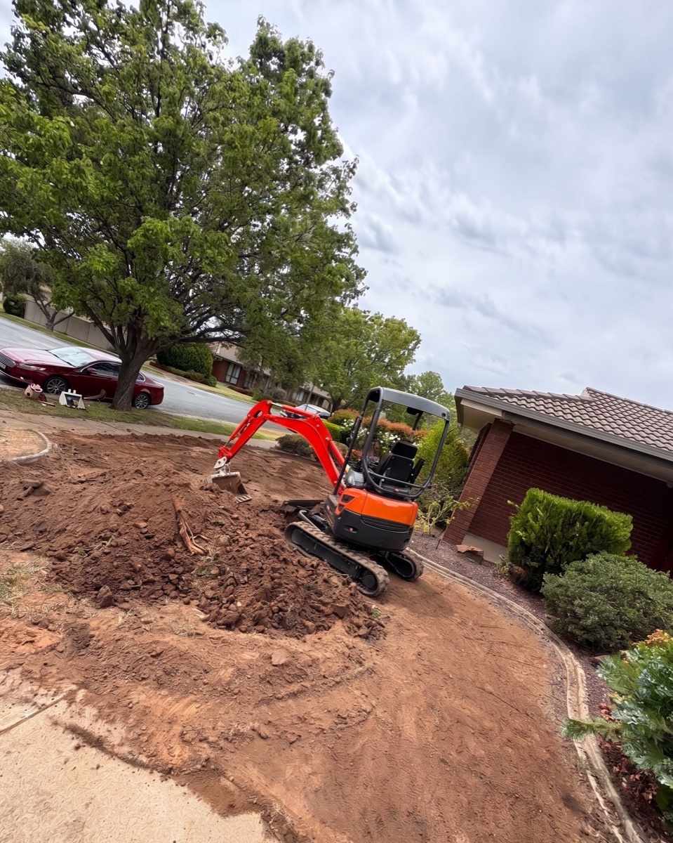 Mini excavator shaping a front yard during the build stage